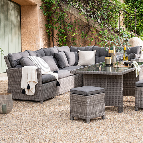 Gartensofa, Esstisch mit Glasplatte und 2 Hocker in grauem Polyrattan mit dunkelgrauen Sitzkissen 