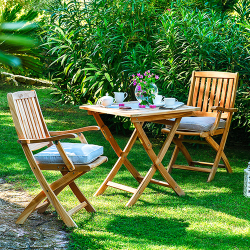 Holz-Gartenmöbel im Landhaus-Look auf Wiese im Grünen, kleiner Klapptisch und 2 Klappstühle
