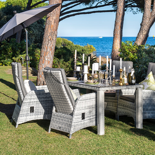 Gartentisch und 4 Gartensessel aus hellgrauem Polyrattan auf Wiese