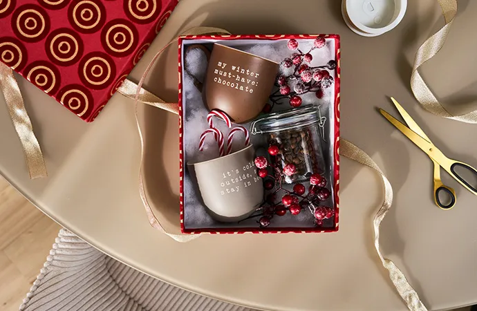 Hand hält eine braune Sprühflasche und sprüht Reiniger auf einen Spiegel