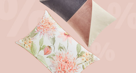 2 Dekokossen, eins mit geometrischer Gestaltung, eins mit floralem Muster, im Hintergrund %%%