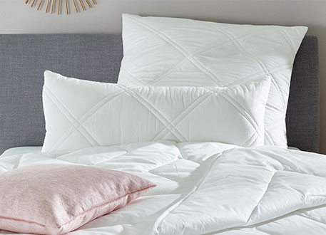 Großes und kleines Kopfkissen auf Bett