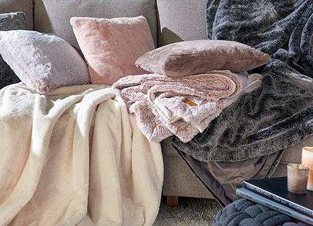 Couch mit vielen Decken in flauschiger Optik