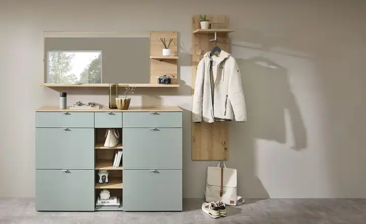 Salbeifarbener Schuhschrank mit Massivholz-Akzenten, Garderobe und Spiegelschrank aus Massivholz an der hellen graubraunen Wand