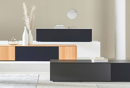3 TV-Lowboards der Serie: Weißer Korpus und schwarze Klappe, Holzdekor und Schwarz kombiniert, komplett schwarz