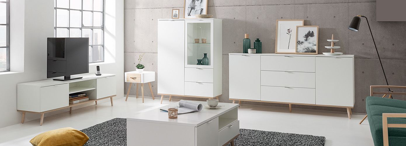 Wohnzimmer mit weißen Möbeln im Skandi-Stil vor Betonwand