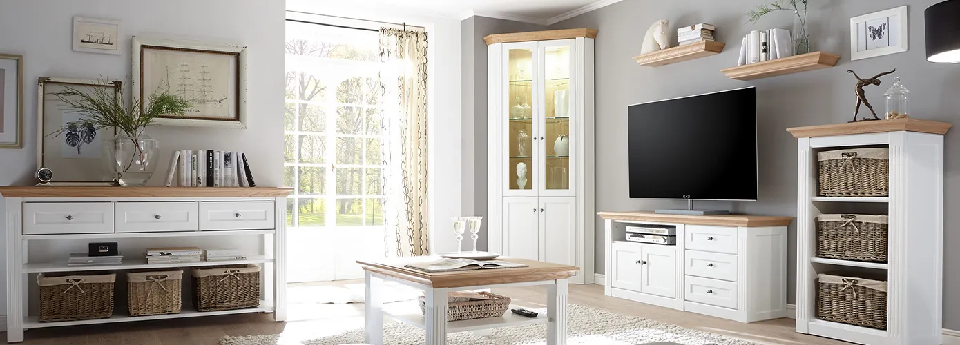 Wohnzimmer mit Landhausmöbeln in Weiß und aus Holz, bestehend aus Konsolentisch, Couchtisch, Eckvitrine, TV-Lowboard, Regal, Wandregale, Deko 