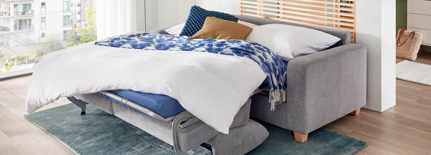 Wohnzimmer mit grauer Schlafcouch, Liegefläche ausgeklappt 