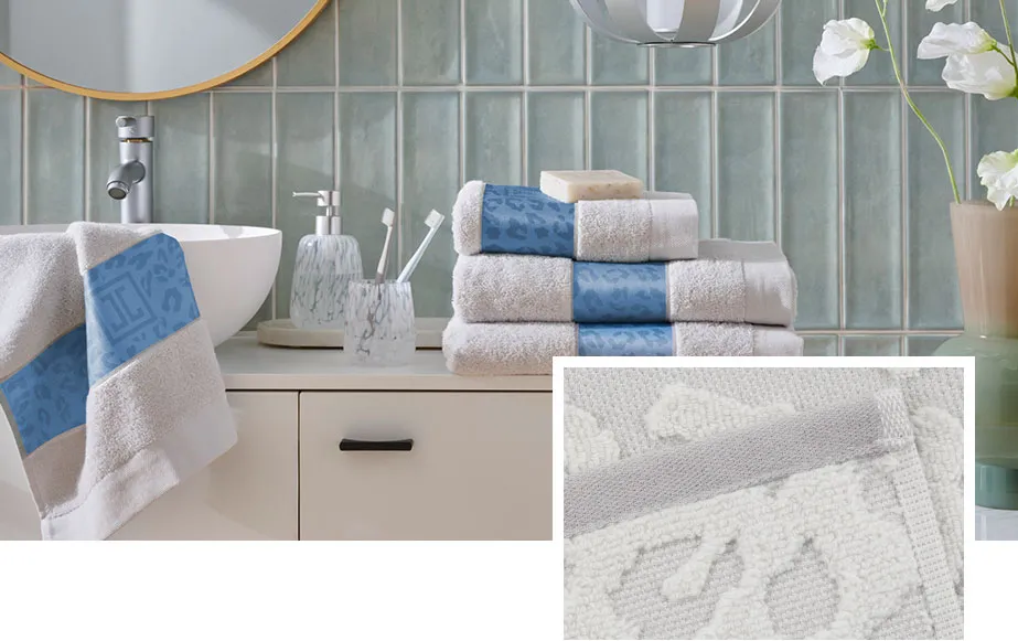 Collage aus 2 Bildern. Bild 1: Waschbecken im Badezimmer, daneben Handtücher in Weiß mit blauer Banderole im Leo-Print, Seifenspender und Zahnbürstenhalter aus Glas mit weißen Tupfen. Bild 2: Nahaufnahme Handtuch im weißen Leo-Muster 