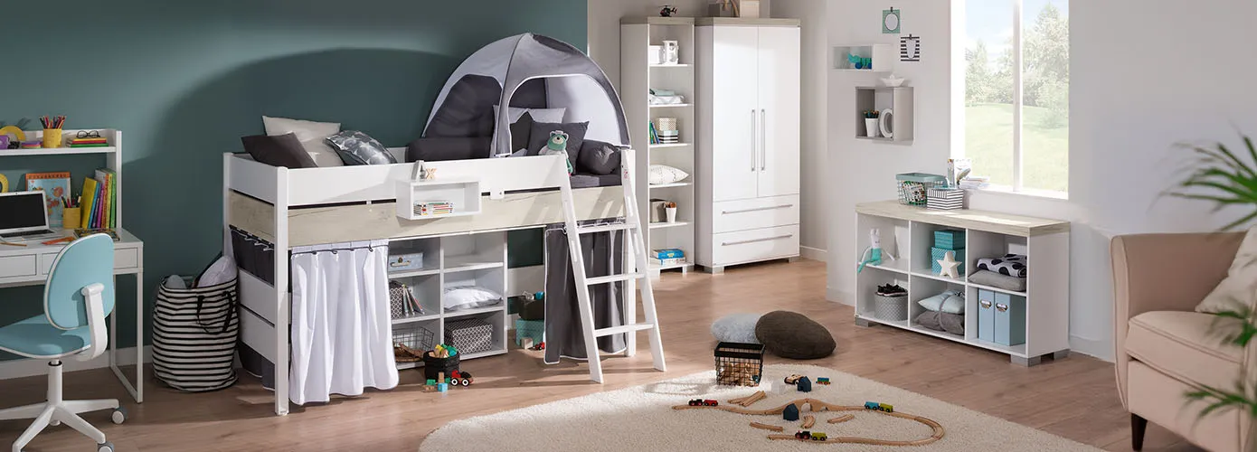 Kinderzimmer mit weißem Schreibtisch, blau-weißem Schreibtischstuhl, Hochbett in Weiß und Holzoptik, 2 Regale und Schrank in Weiß und Holzoptik, rosa Sessel, Deko