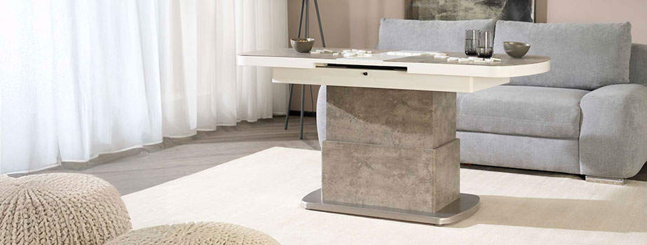 Wohnzimmeransicht mit weiß betonfarbenen Tisch, grauem Sofa dahinter