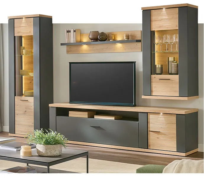 Wohnwand in Anthrazit und Holzoptik mit Beleuchtung und Deko.